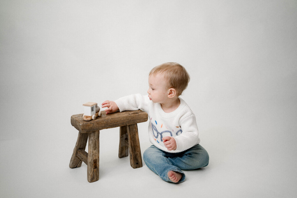 boy playing with small wooden train 