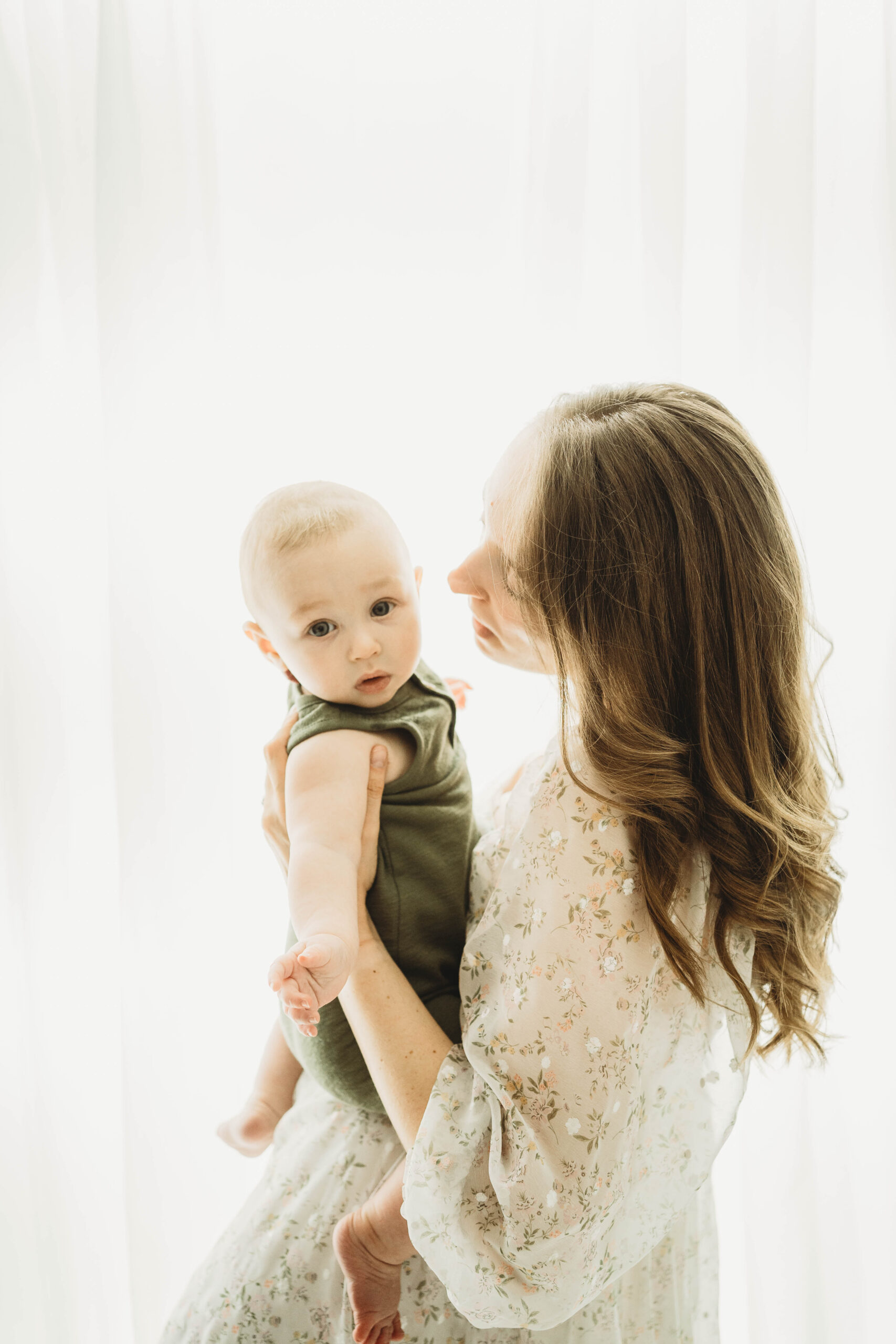 Mother holding son in green overalls