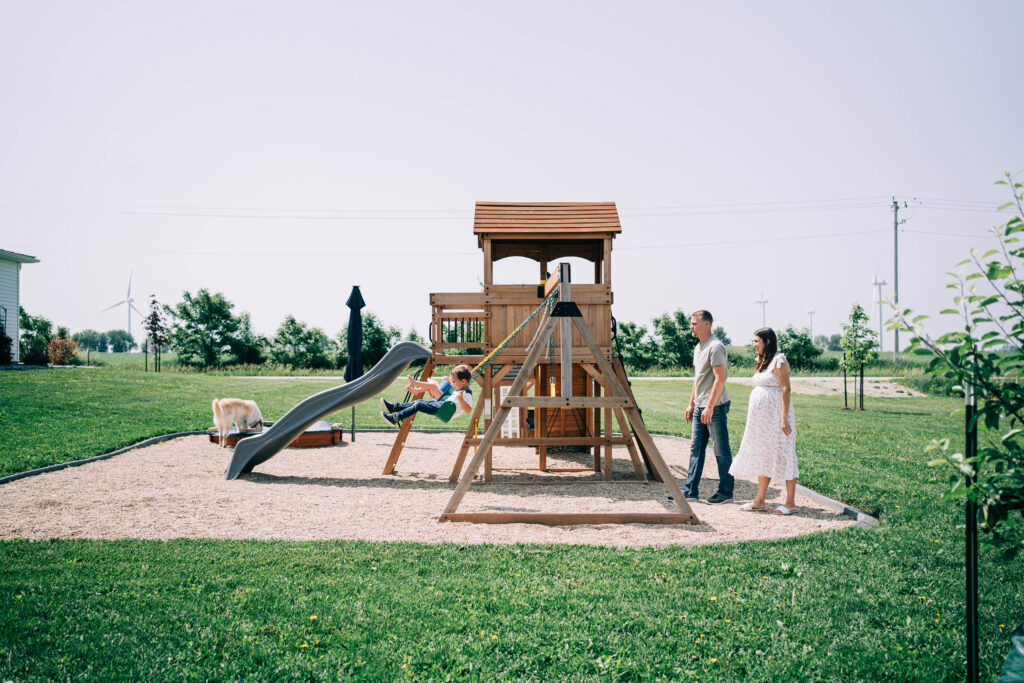 pregnant woman playing outside with her family during their lifestyle maternity session