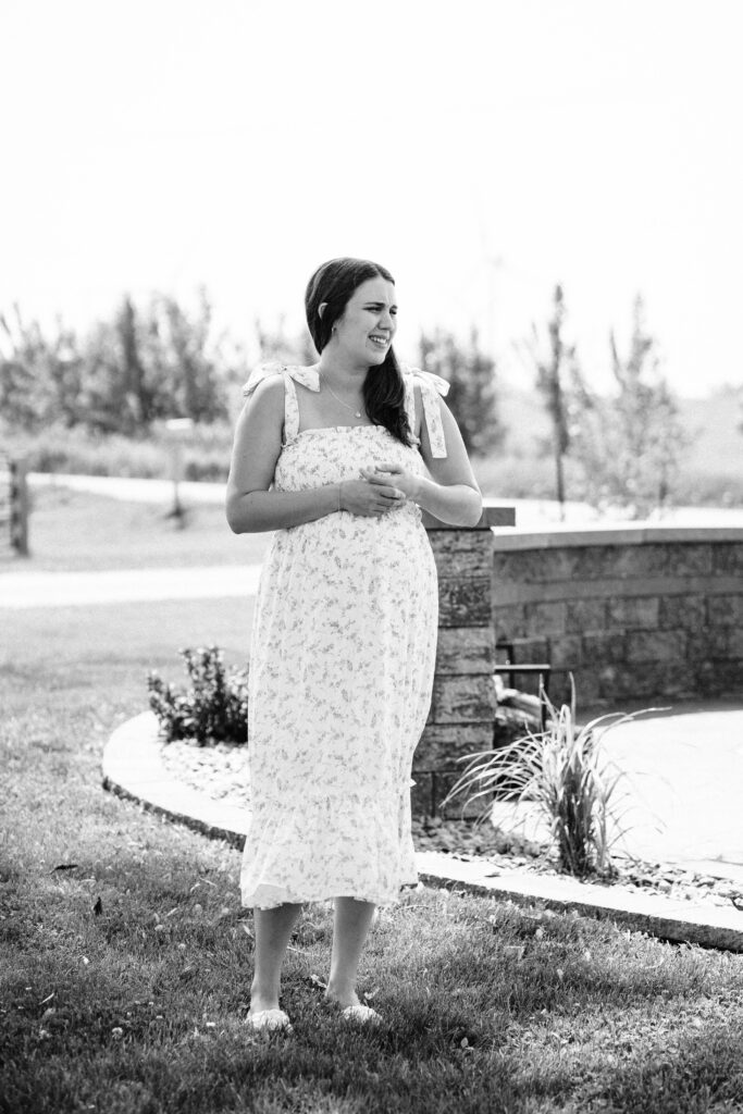 black and white photo of a woman wearing a white dress while being photographed for her in home lifestyle session