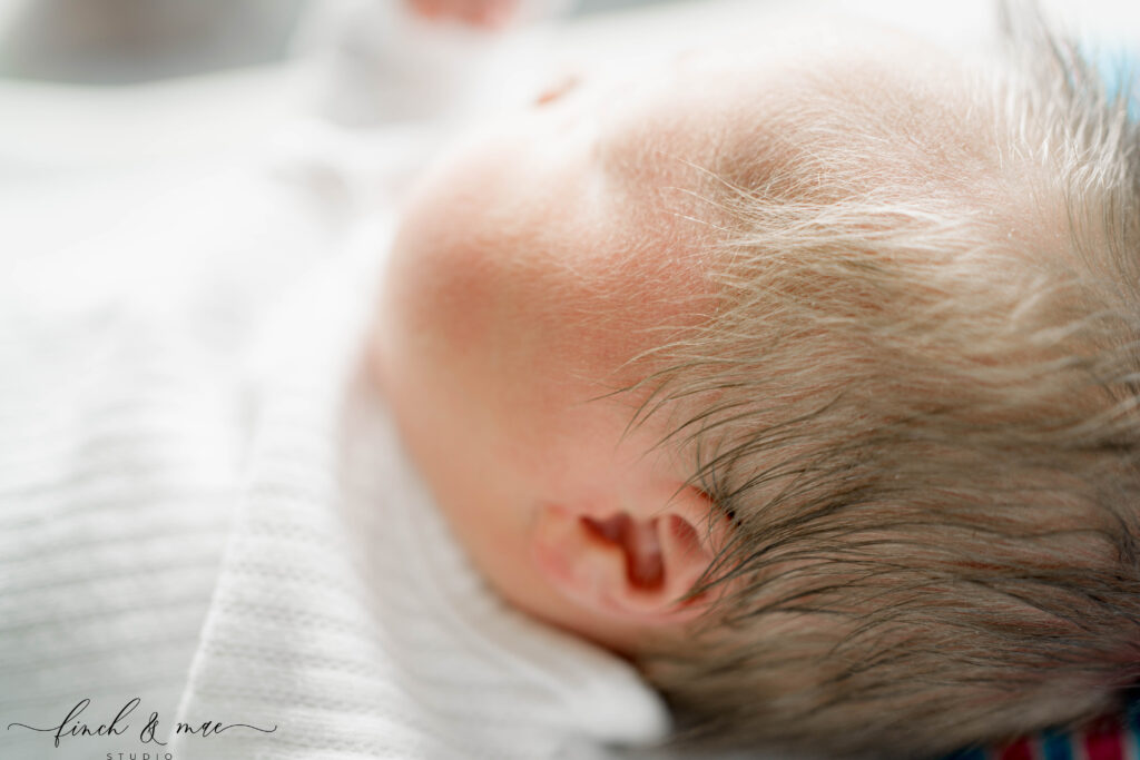 Close-up detail of newborn’s soft hair and ear during Fresh 48 hospital photography.