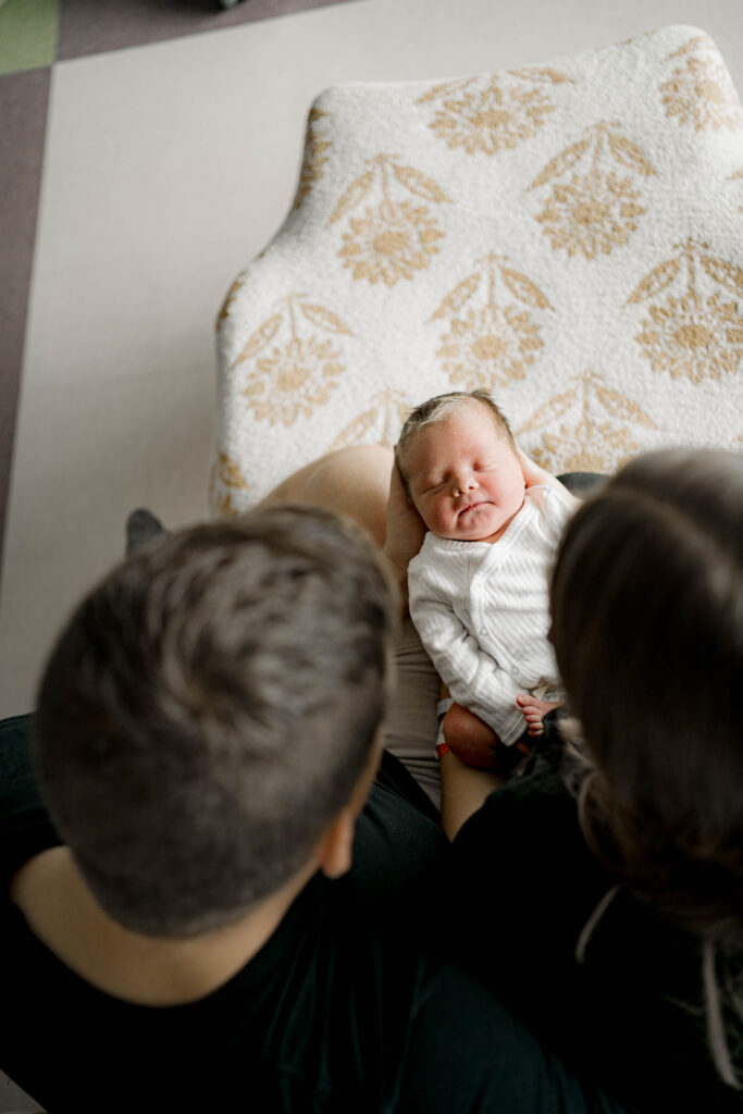 Newborn baby cradled in parents’ arms during Fresh 48 hospital photography in Sun Prairie, Wisconsin.