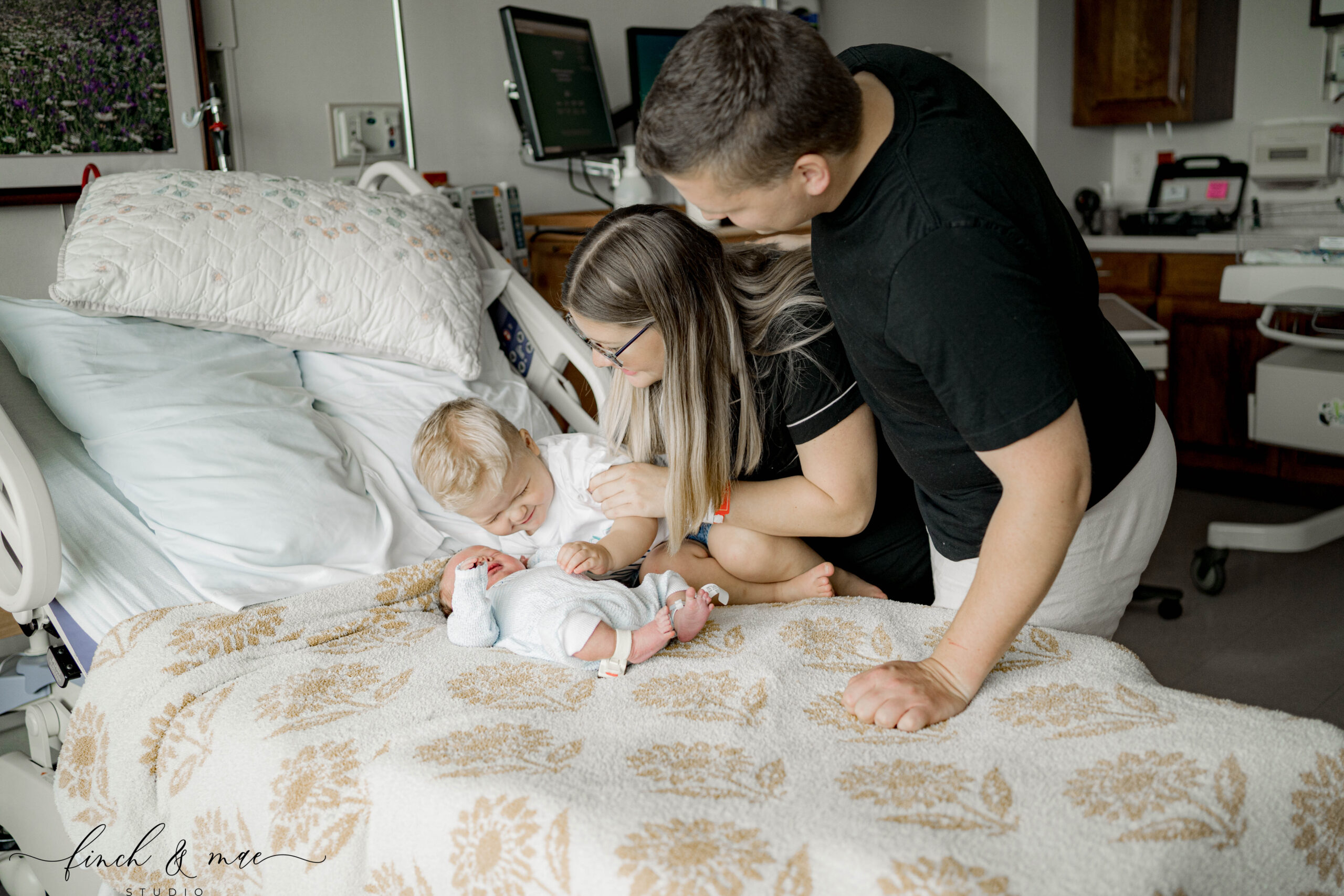 Parents and big brother meeting their newborn baby during a Fresh 48 hospital session in Madison, WI.