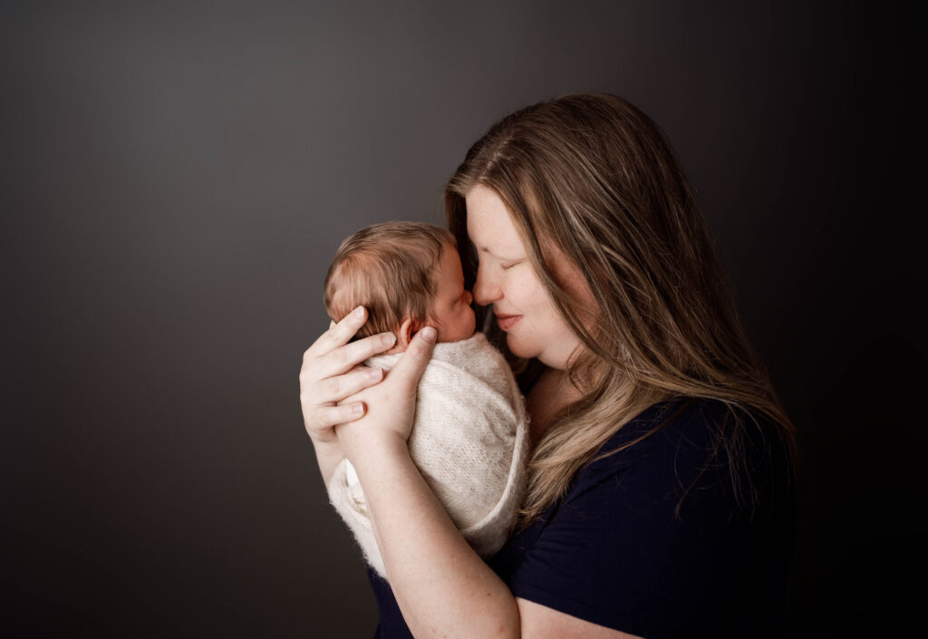 mom holding her newborn son while their noses touch in rio, wi newborn session