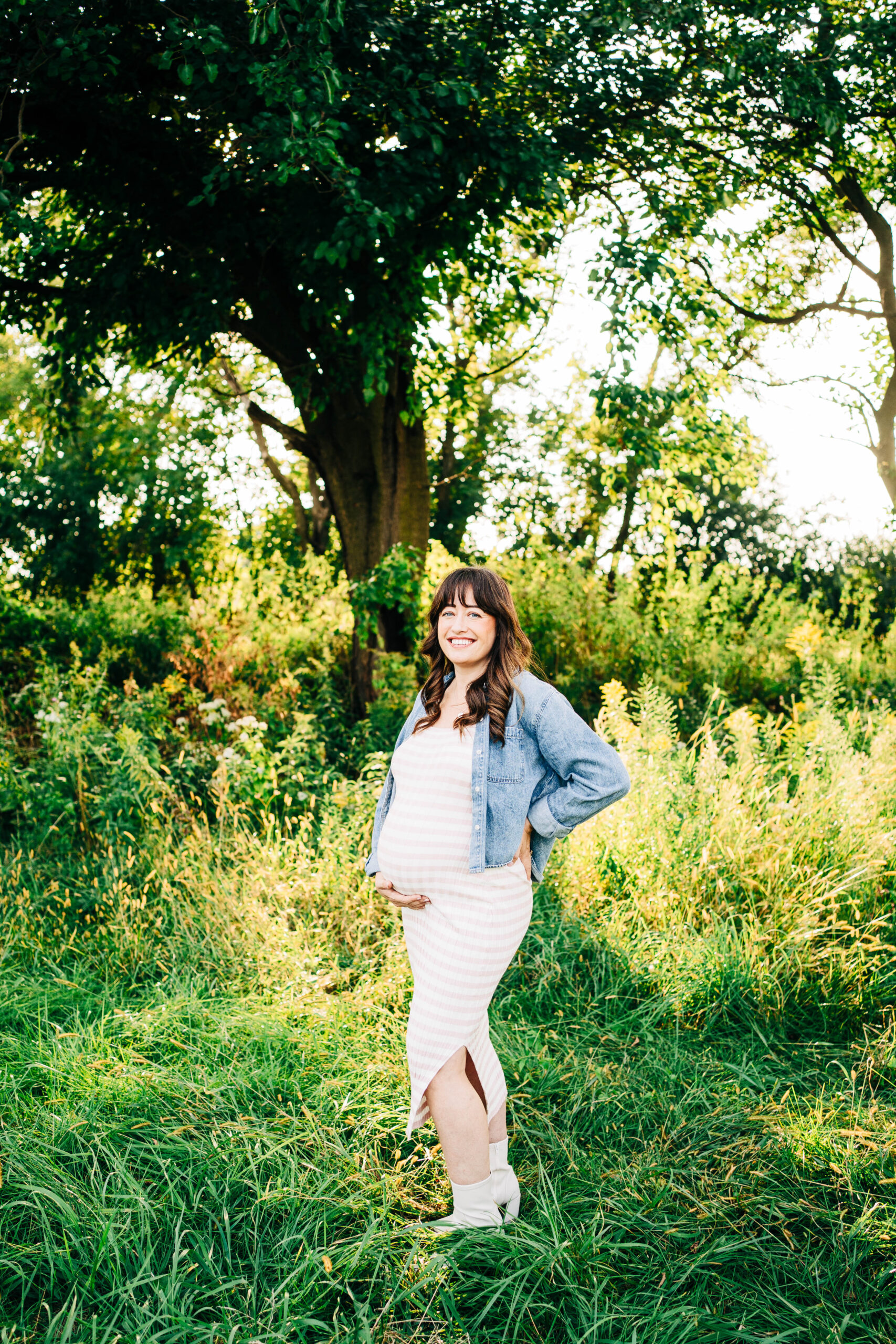 pregnant mom standing in tall green grass for maternity session in sun prairie wi