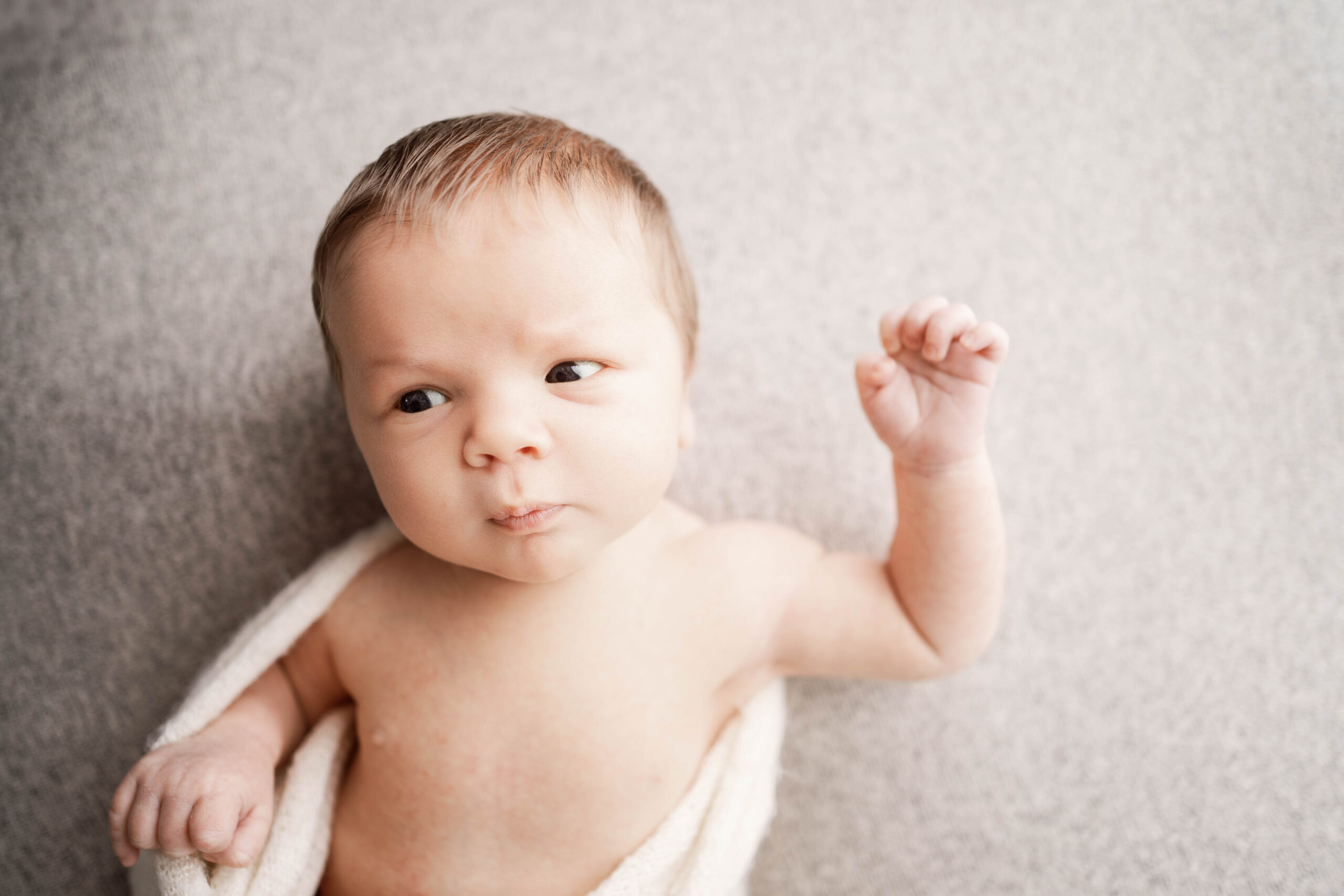 newborn boy laying on a cream backdrop for his newborn session in rio, wi.