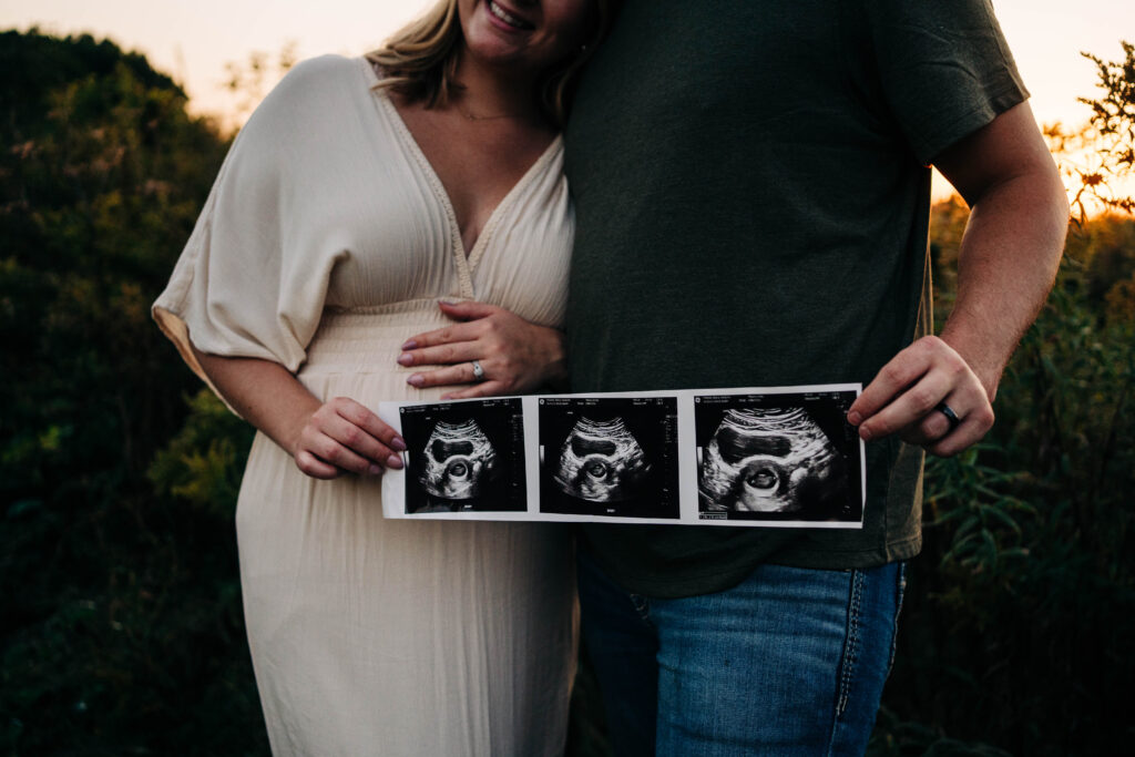 Mom and dad are holding ultrasound pictures in Wisconsin field