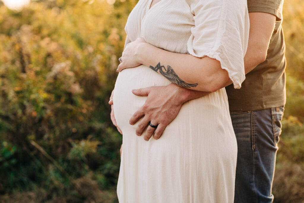 Hey, Dad is standing behind Mom and caressing her expecting belly with her