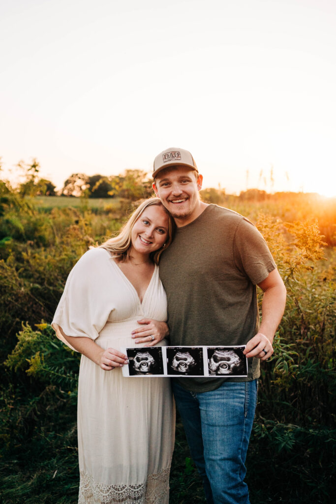A husband and wife expecting a baby and holding an ultrasound scan together