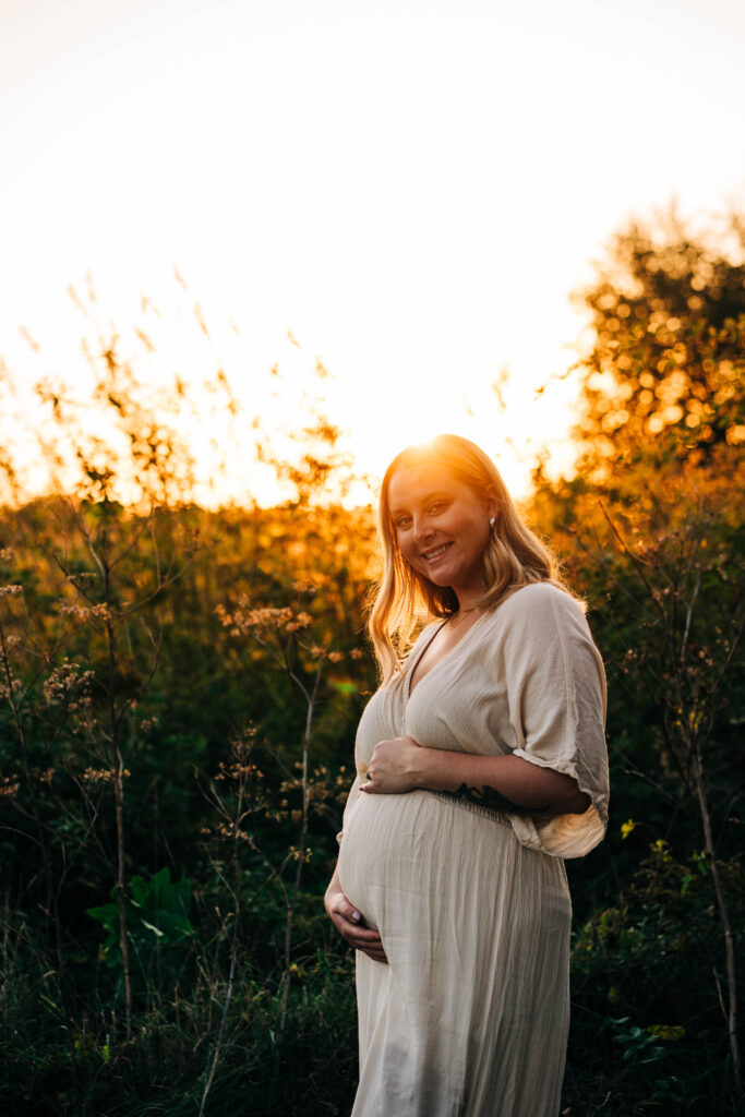 And expecting mother is caressing her belly with the golden glow of Wisconsin behind her