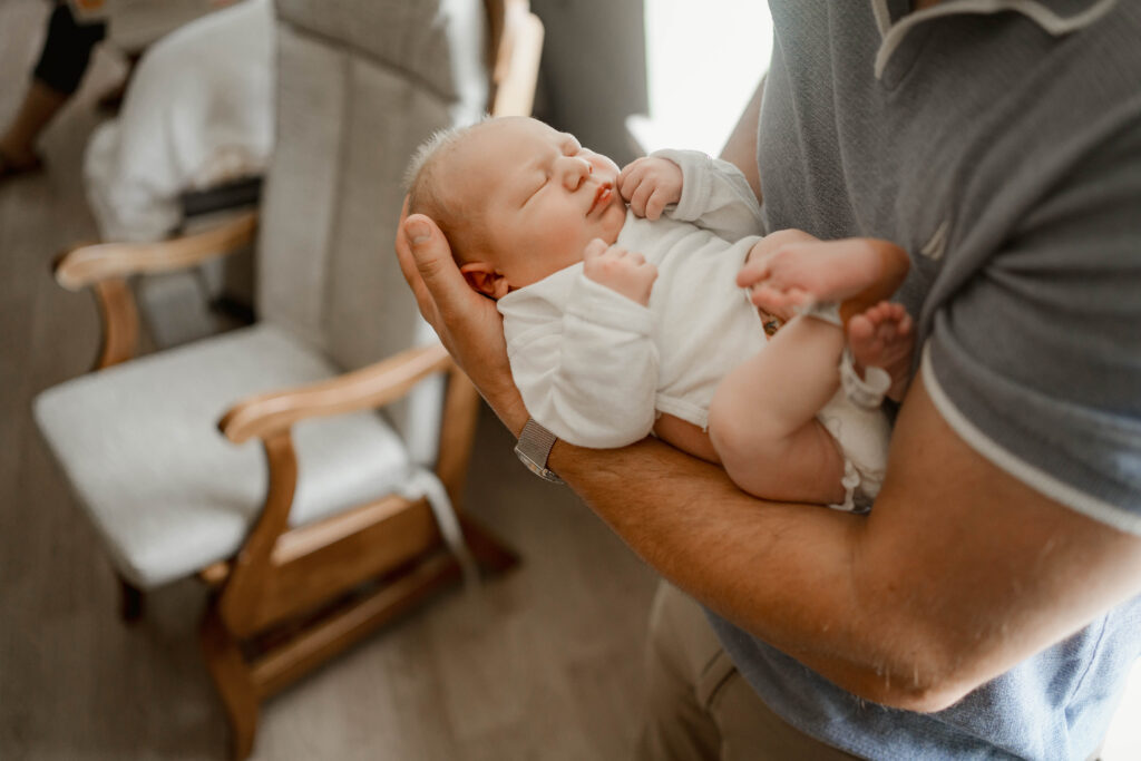 dad holding newborn baby at fresh 48 hospital session near madison wi