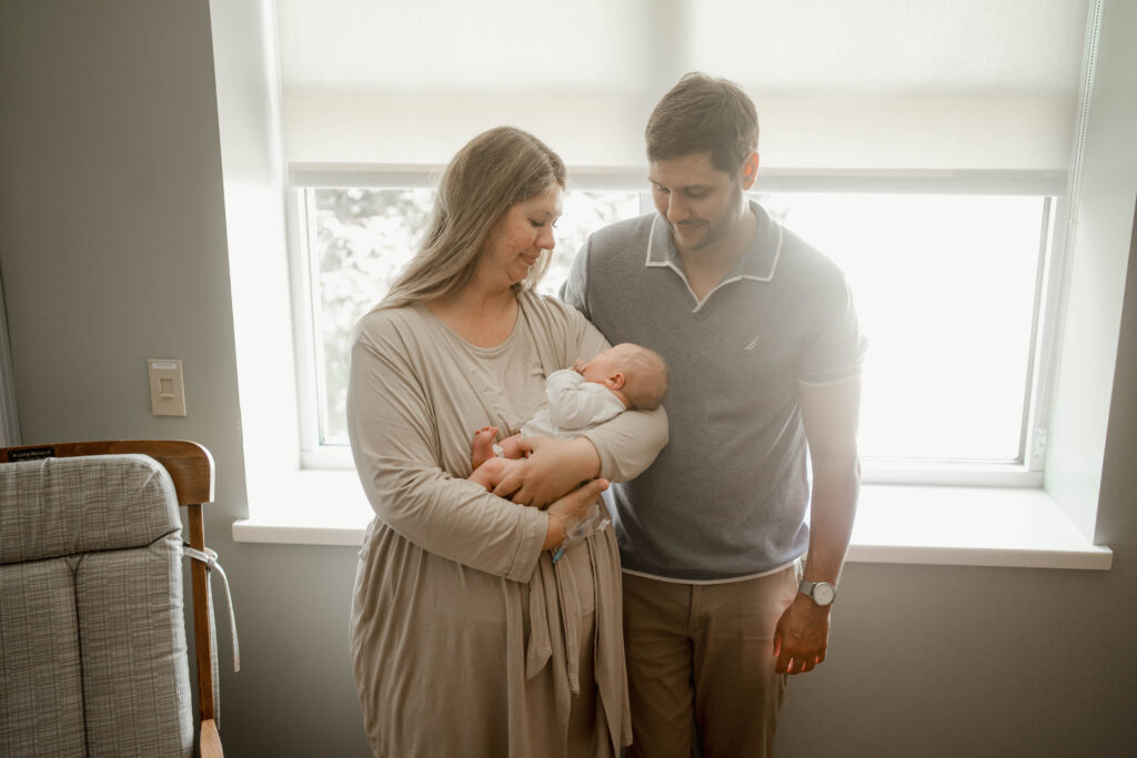 mom and dad looking at newborn baby in fresh 48 hospital session near madison wi 