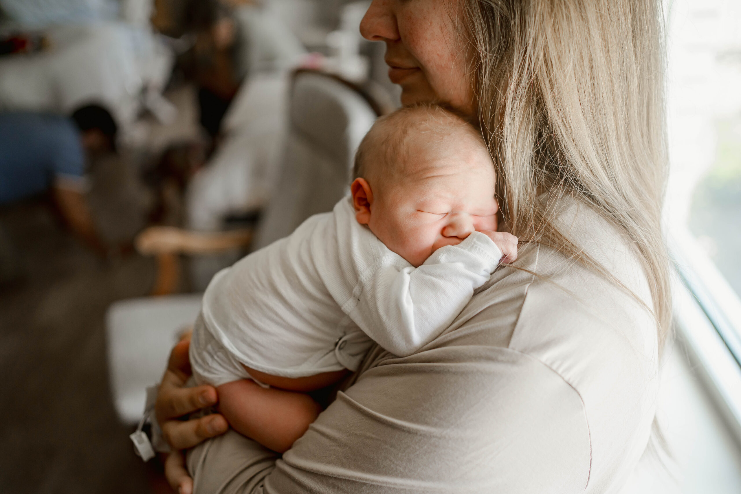 baby snuggling on mom's shoulder during their fresh 48 hospital session near milwaukee wi