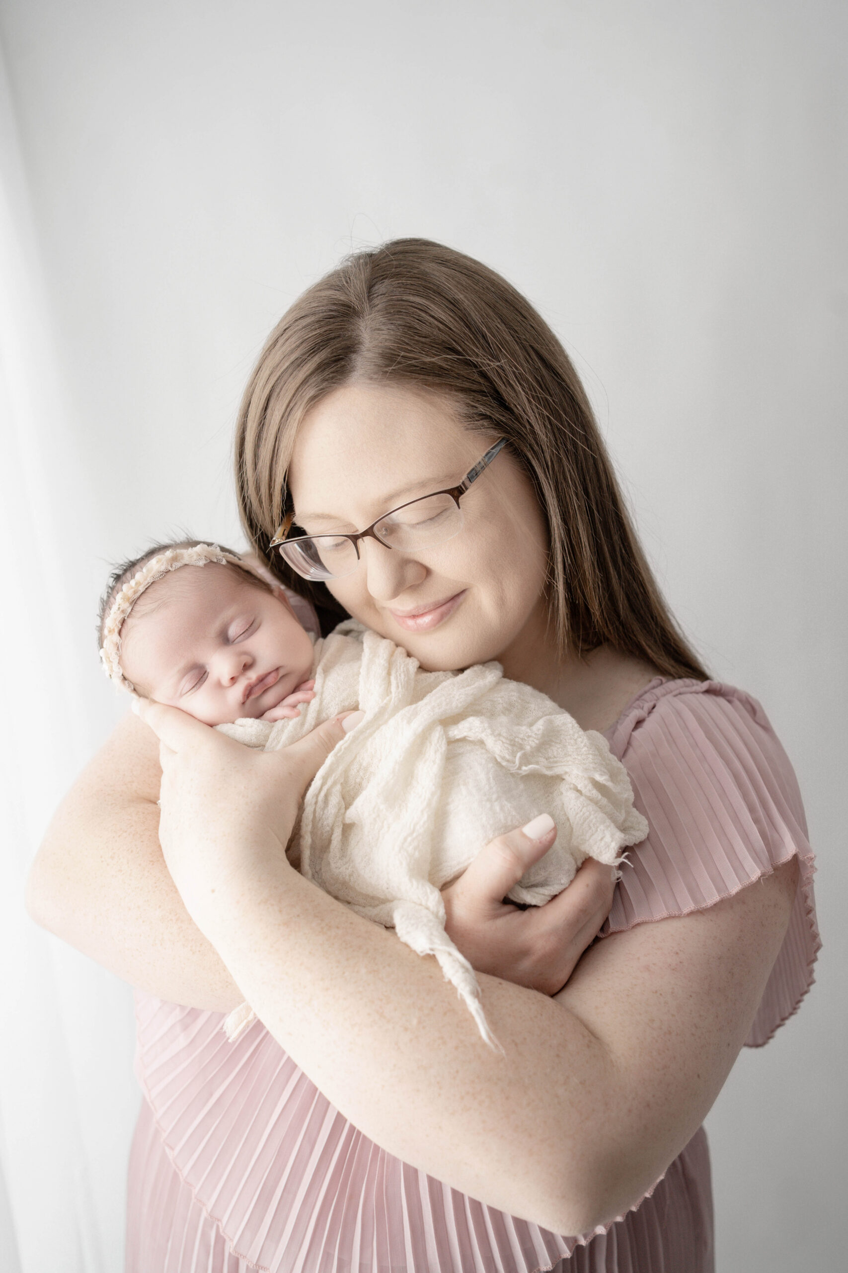 mother holding newborn in soft neutral studio lighting in Rio, WI