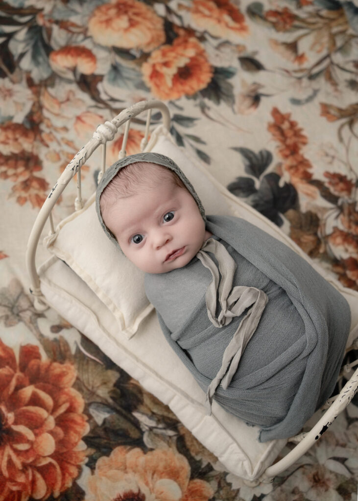 Awake newborn in heirloom baby bed studio portrait wisconsin 