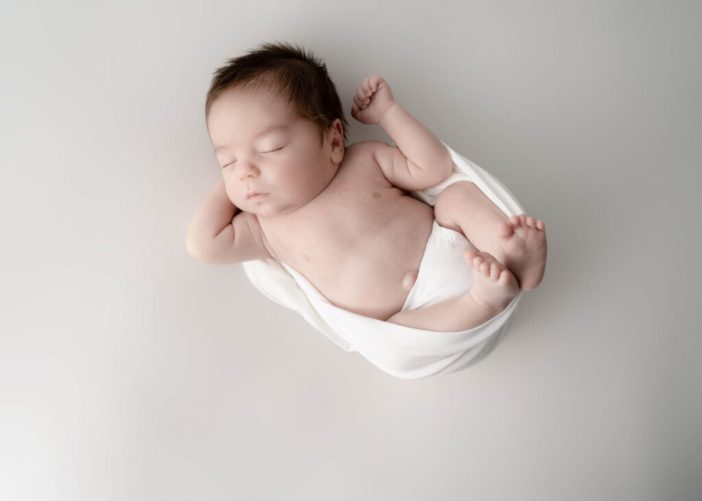 newborn baby boy wrapped in a white knit wrap in rio, wi newborn studio