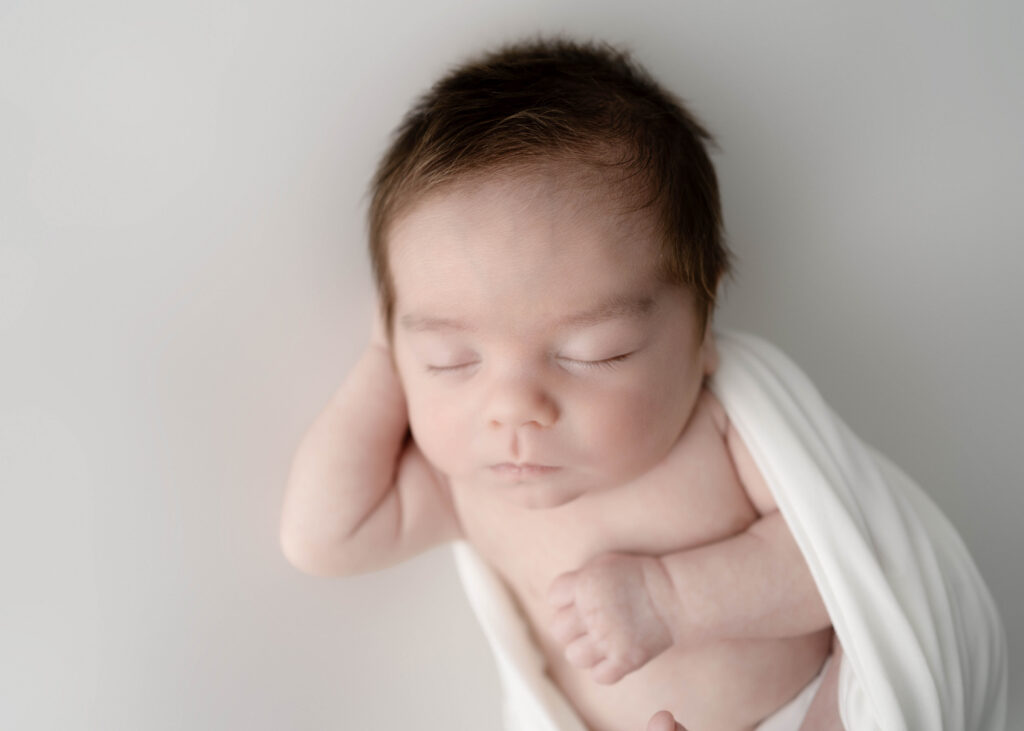 baby boy wrapped in a white knit wrap
