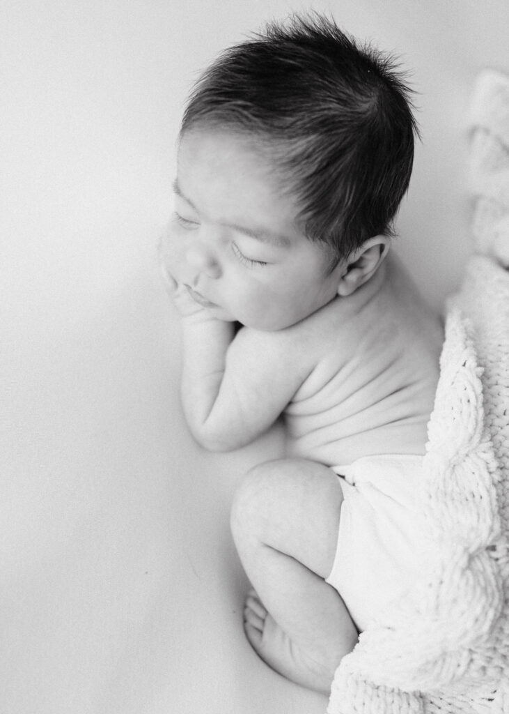 black and white photo of a sleeping newborn baby at his newborn session