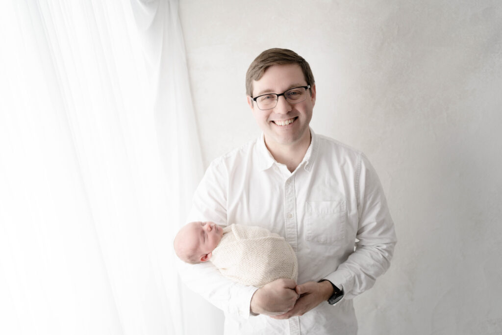 Dad holding newborn baby during a family newborn photography session in Southern Wisconsin.