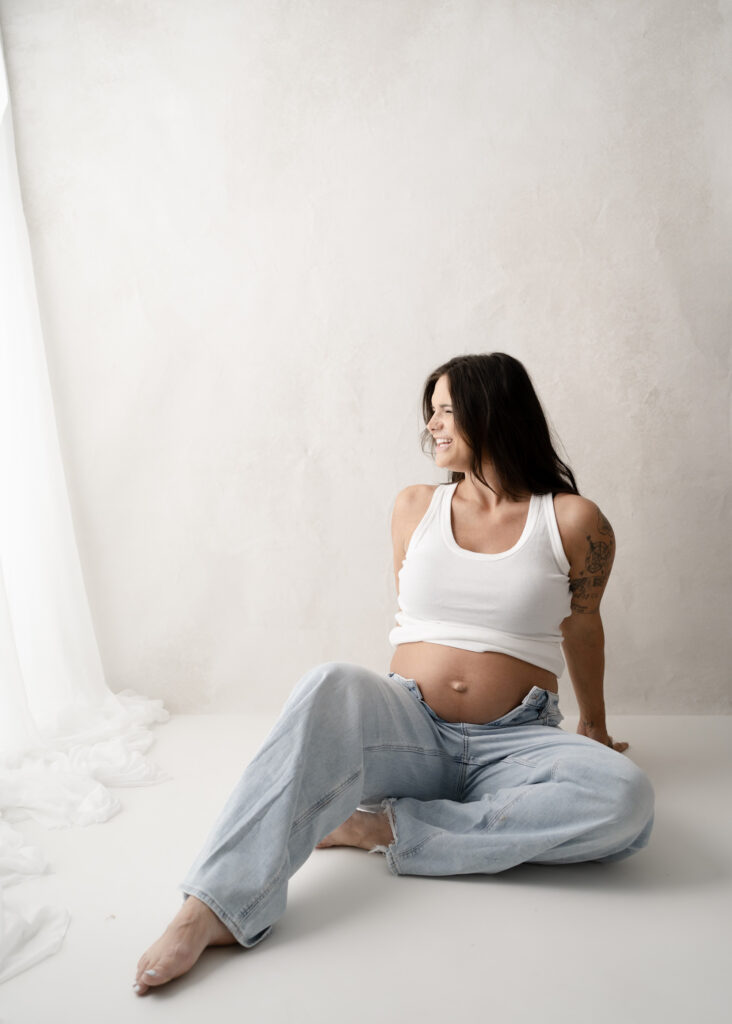 Pregnant mother posing in a neutral studio setting during a maternity photography session in Rio, Wisconsin.