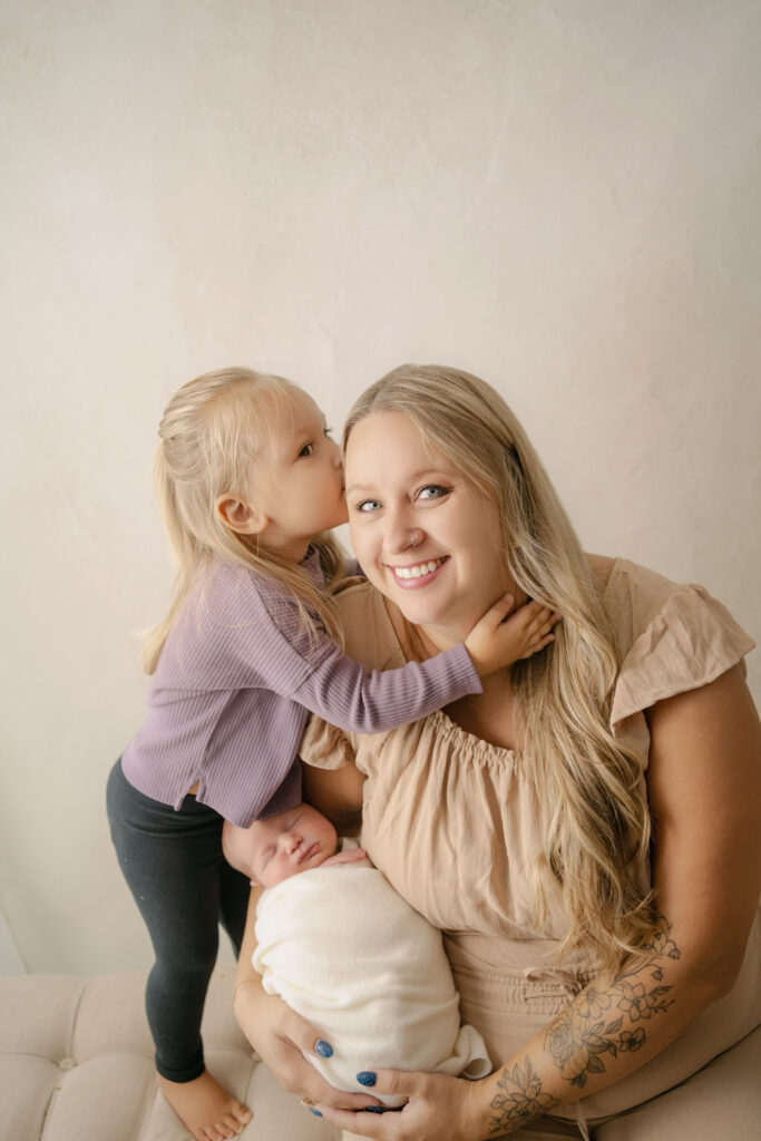 Daughter kissing her mom's cheek - Newborn photography session near Madison, WI