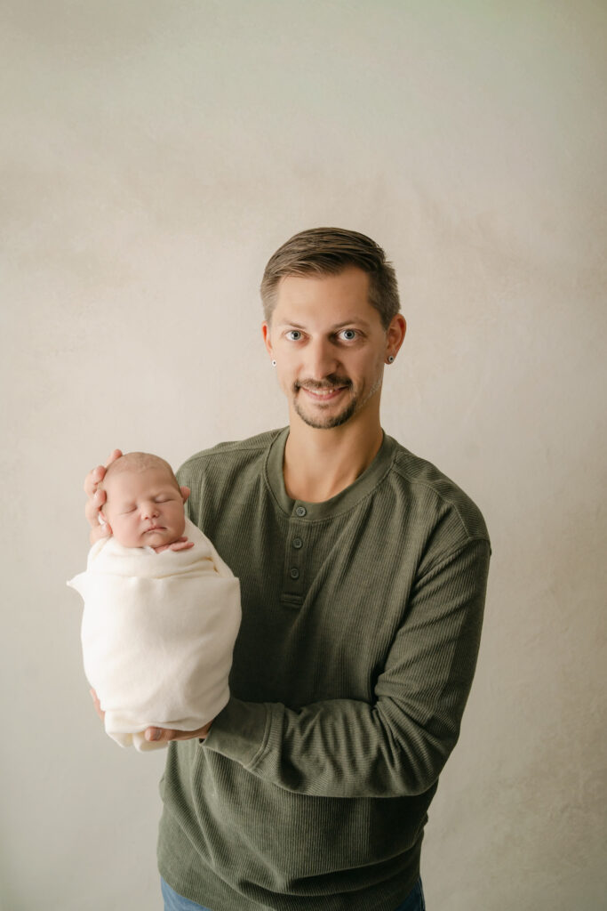 Dad showing off newborn son - Newborn photography session near Madison, WI