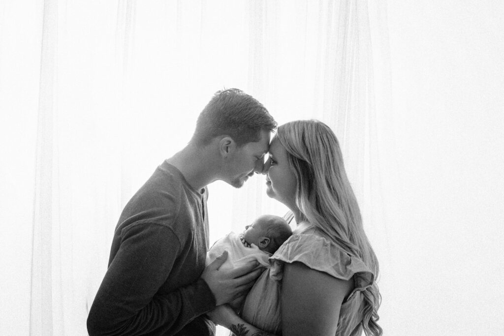 black and white backlit image of parents with newborn son- Newborn photography session near Sun Prairie, WI