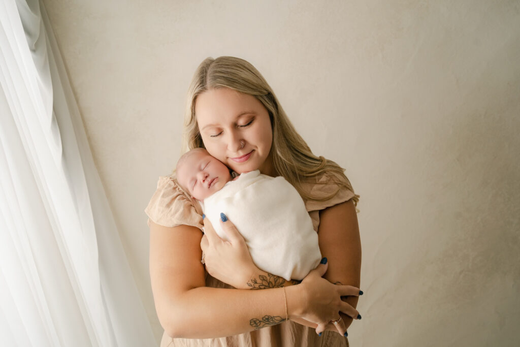 Mom holding newborn son close - Newborn photography session near Madison, WI