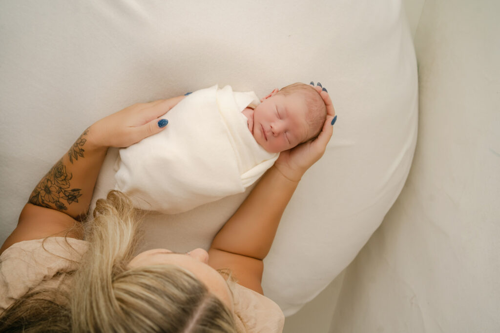 mom holding newborn son in rio, wi newborn studio