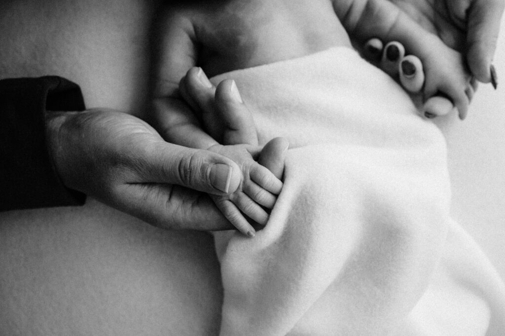 black and white image of parents holding newborn son's hands -
Newborn photography session near Madison, WI