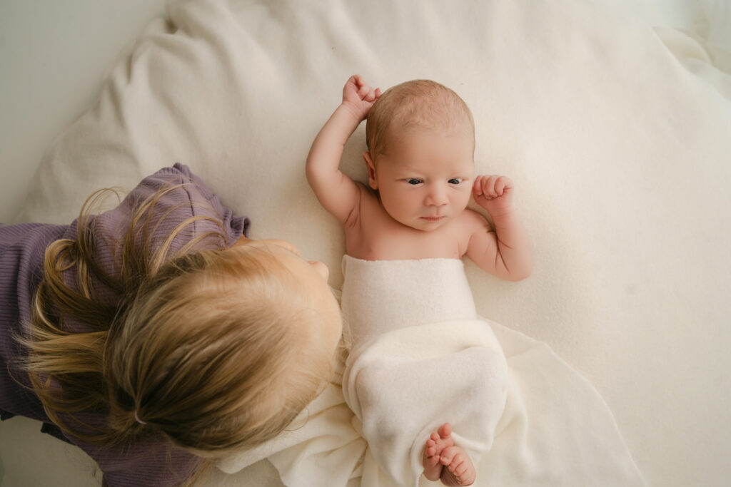 big sister admiring newborn brother - Newborn photography session near Madison, WI