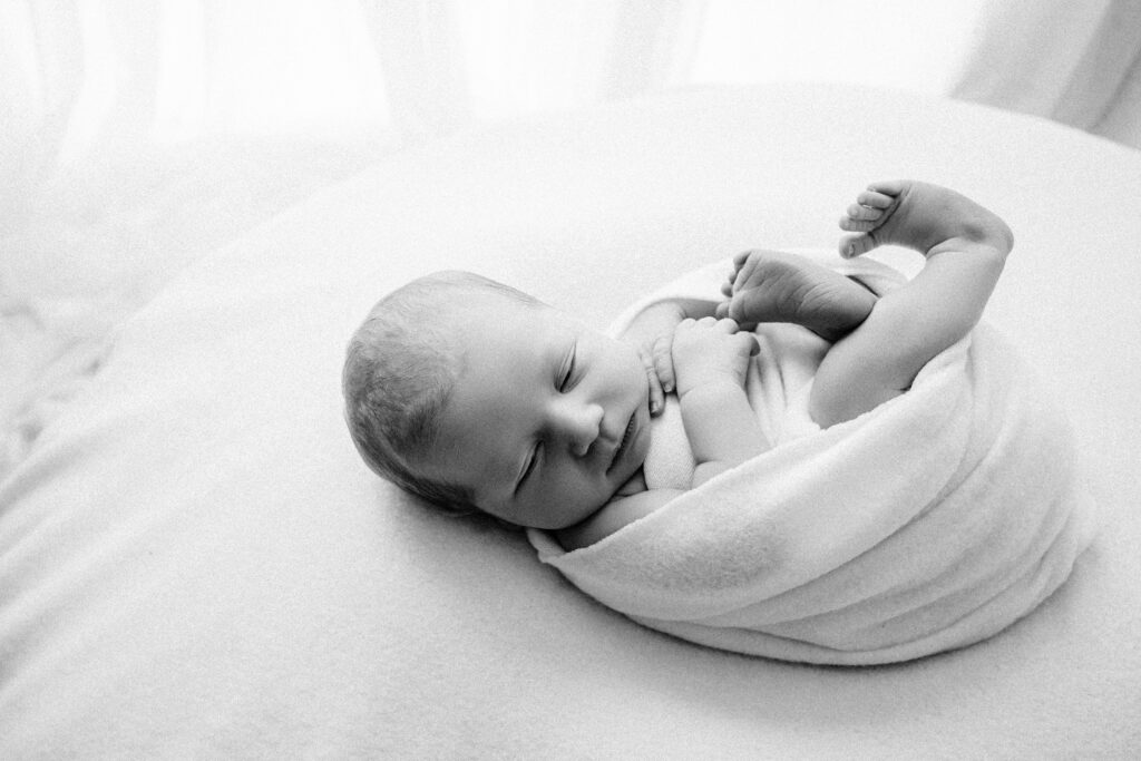 black and white image of newborn wrapped in a white wrap - Newborn photography session near Madison, WI