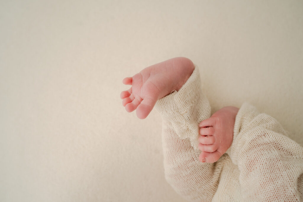 newborn wearing cream pants with their little feet - Newborn photography session near Madison, WI